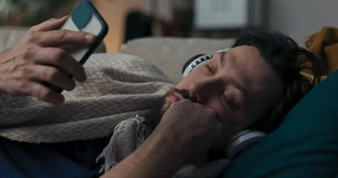 Close-up of tired man with beard and black hair. Brunette is lying on sofa Stockbeeldmateriaal 218330404