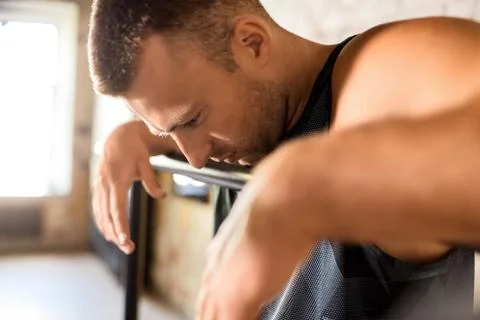 Close up of tired man at parallel bars in gym Stock Photos