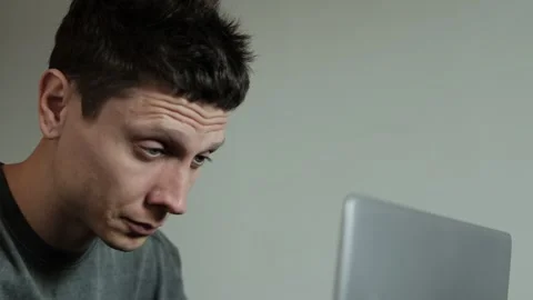 Close-up of tired man taking off glasses rubbing eyes while sitting at computer Stock Footage 308645689
