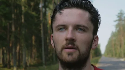 Close-up of tired runner of marathon running down the road near a forest Stock Footage 75541239