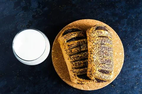 Close-up of toasted bread slice and glass of milk on dark surface Stock Photos