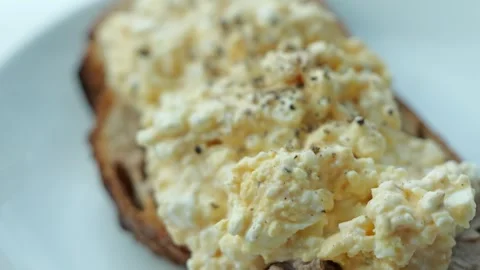 Close-up of toasted bread topped with mashed boiled eggs, cottage cheese, and Stock Footage 344398362