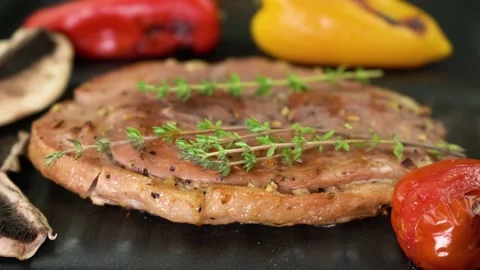 Close-up, toasty gammon steak cooking on the grill with thyme and vegetables, 4K Stock Footage 132464591
