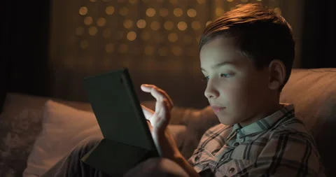 Close-up of toddler boy holding digital tablet device at night Stock Footage 247621910