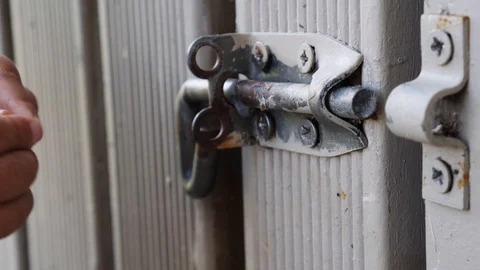 Close up of toddler hand playing with a lock on a gate Stock Footage 100524160