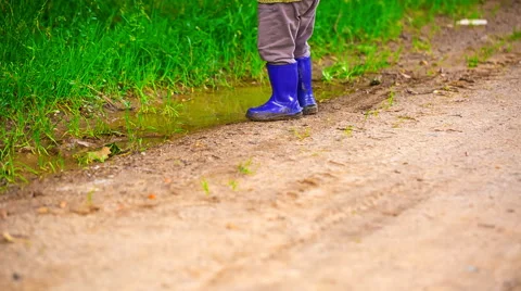Close up of toddler in rubber boots. Full HD RAW video Stock Footage 58670353