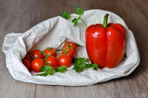 Close-up of tomato clusters , red pepper and parsley leaves  in a hemp bag. O Stock Photos