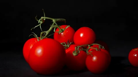Close up of a tomato falling on a stack of tomatoes in slowmotion with a Video stock 264011638