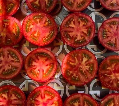 A close up of a tomato slice with the stem still attached Stock Photos