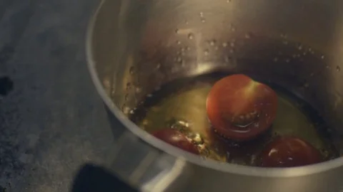 Close up tomatoes in oil in a frying pan Stock Footage 70385448