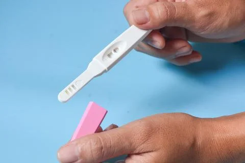 Close up of a tool for checking pregnancy that is being opened and marked w.. Stock Photos