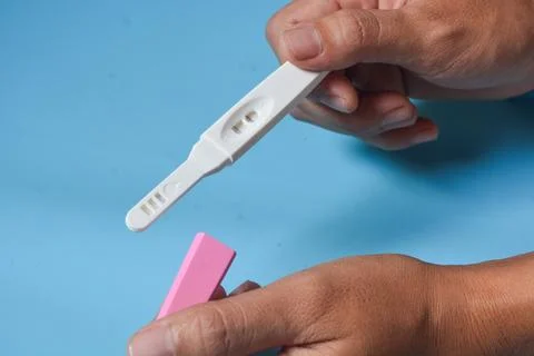 Close up of a tool for checking pregnancy that is being opened and marked w.. Stock Photos