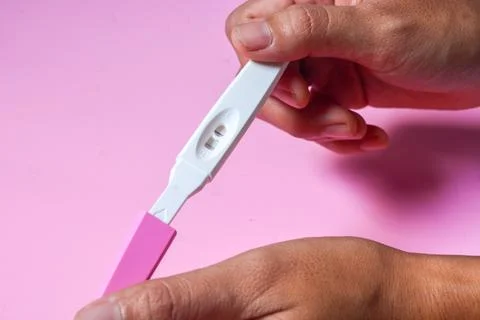 Close up of a tool for checking pregnancy that is being opened and marked w.. Stock Photos