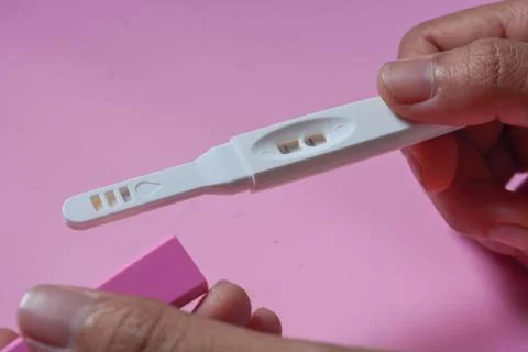 Close up of a tool for checking pregnancy that is being opened and marked w.. Stock Photos