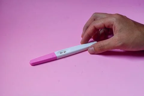 Close up of a tool for checking pregnancy that is being opened and marked w.. Stock Photos