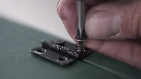 Close Up Of Tools Screwdriver Turning A Screw. Cam Lock Screw is inserted using Stock Footage 150782735