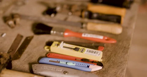 Close up of tools stacked next to eachother on top of table inside garage Stock Footage 163242002