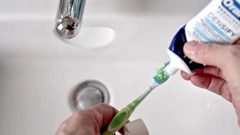 Close-Up Of Toothbrush And Toothpaste In A Bathroom Sink For Daily Dental Care Stock Footage 325418356