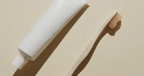 Close up of toothbrush and toothpaste on beige background Stock Footage 234368828