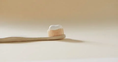 Close up of toothbrush with toothpaste on beige background Stock Footage 331208216