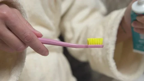 Close-up of toothpaste being applied to a toothbrush. An unrecognizable woman Stock Footage 195090726