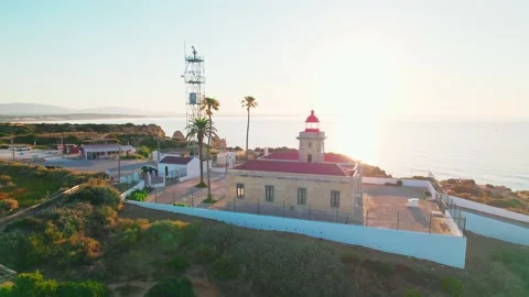A close-up top aerial look of a sunset over a Lighthouse in Algarve in 4K. Stock Footage 163374460