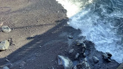 Close up top angle of sea waves breaking on black sandy beach. Slow motion, 4K Stock Footage 196276924