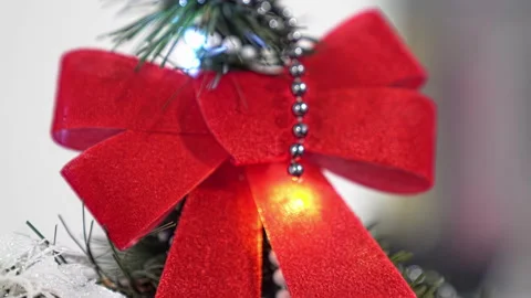 Close-up, top of the Christmas tree with red bow, zoom out from camera. 4k. Stock Footage 219545746