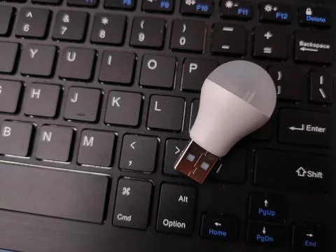 A close-up, top-down studio shot featuring a small white USB LED light bulb.. Фото
