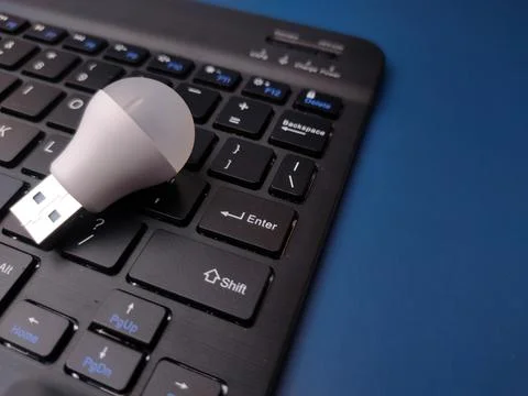 A close-up, top-down studio shot featuring a small white USB LED light bulb.. Photos