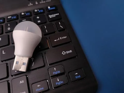 A close-up, top-down studio shot featuring a small white USB LED light bulb.. 写真素材