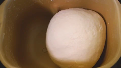 A close up top down view of dough being kneaded in a bread maker. Stock Footage 249807053