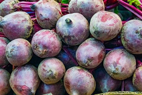 Close-up top-down view of a pile of fresh purple beetroot at a market. Stock Photos