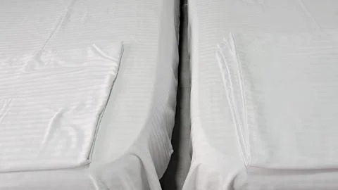 A close-up, top-down view of two twin beds featuring crisp white striped line Stock Photos