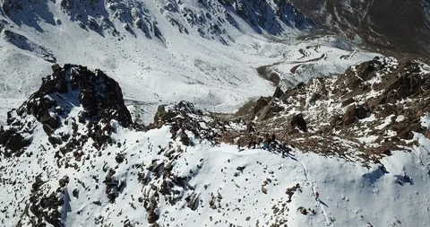 Close to the top of the drone. A group of climbers is at the top of the peak. Video stock 95988456
