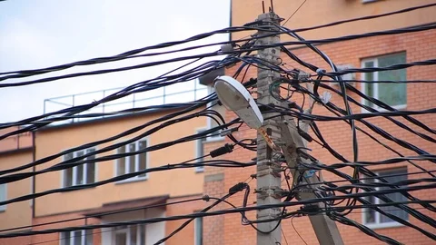 Close-up top of electric post with wires in chaotic manner and piece of package Video stock 101540264