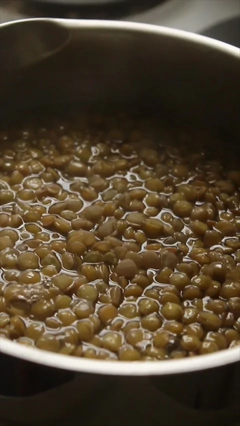Close-up top-front shot of lentils boiling in a metal pot. Stock Footage 304005877
