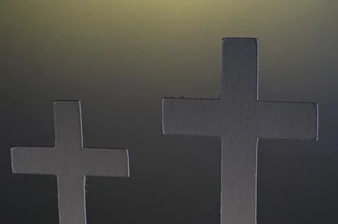 Close up on top portion of cross with hints of yellow light Stock Photos