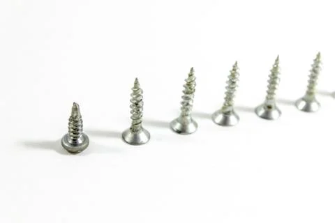 Close-up top shoot of multiple screws on white blurry background Stock Photos