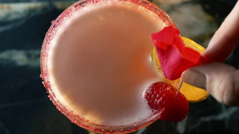 Close-up top shot of a refreshing cocktail on a bar and a female hand decorating Stock Footage 156548129