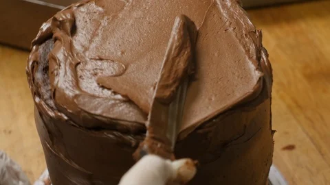 Close up of top of tiered cake spreading frosting Stock-Footage 94264584