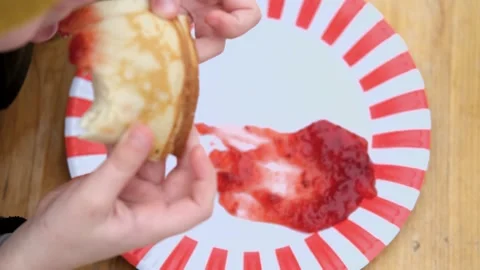 Close up top view boy eating pancake with jam Video stock 303717597
