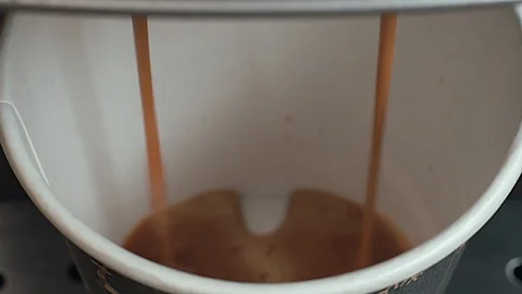 Close up, top view, Coffee is poured into a cardboard (disposable) Cup Stock Footage 110910659
