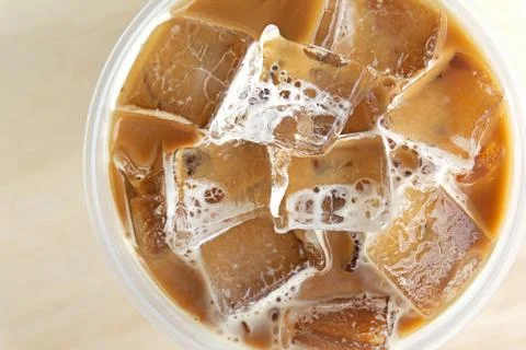 Close up top view cold coffee drink with ice on old wood table Stock Photos
