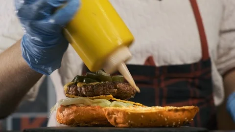 Close-up top view of a cook's hands cooking a hamburger. 库存影片 119263419
