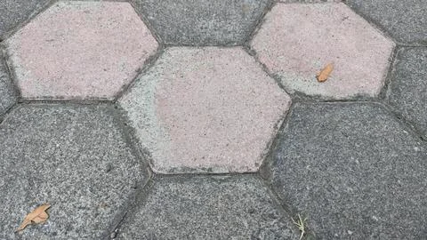 A close up top view displays interlocking hexagonal concrete paving stones .. Stock Photos