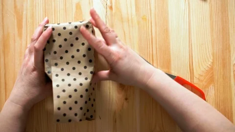 Close-up top view of female hands packing gift. 動画素材 105945915