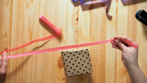 Close-up top view of female hands packing gift. Stock Footage 105946217