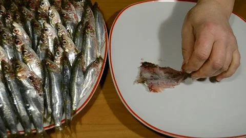 Close-up top view of female hands cleaning fresh sardines fish on fillet. Stock Footage 150703129