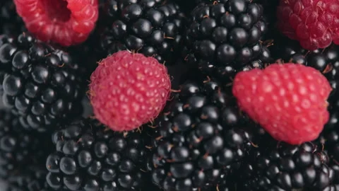 Close up top view of fresh raspberries, blackberries rotate Video stock 284083974